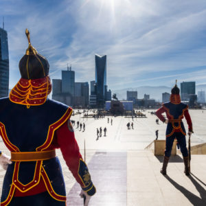 Soldats mongols en tenue d'apparat postés devant le bâtiment du Parlement. Vus de dos. Au fond, des immeubles et gratte-ciels. Ulan Bator - Mongolie - 2013. © Grégory Dziedzic Photography