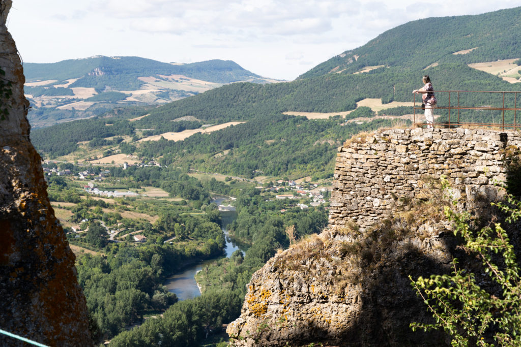 Une femme visitant le château de Peyrelade contemple les gorges du Tarn depuis un chemin de promenade du château. Rivière-sur-Tarn, août 2020.