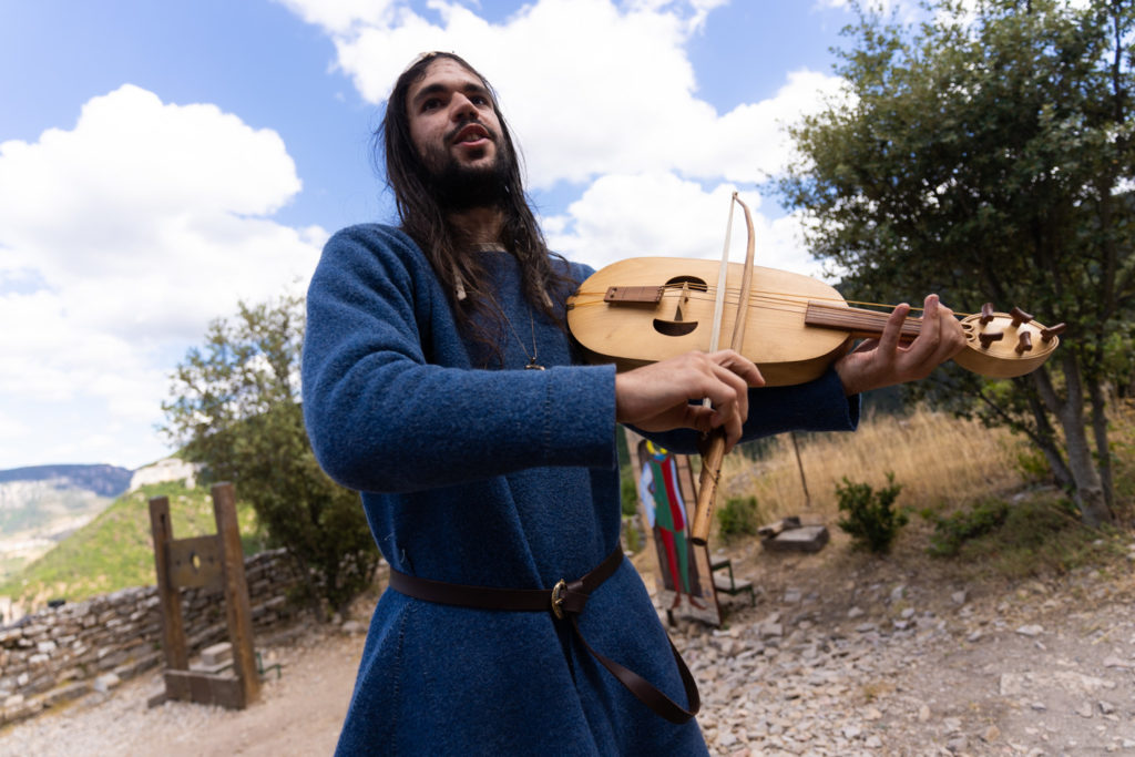 Bohémond le troubadour, membre de la compagnie médiévale "Les Faydits d'Oc", joue de la viole pendant une représentation au château de Peyrelade. Rivière-sur-Tarn, août 2020.