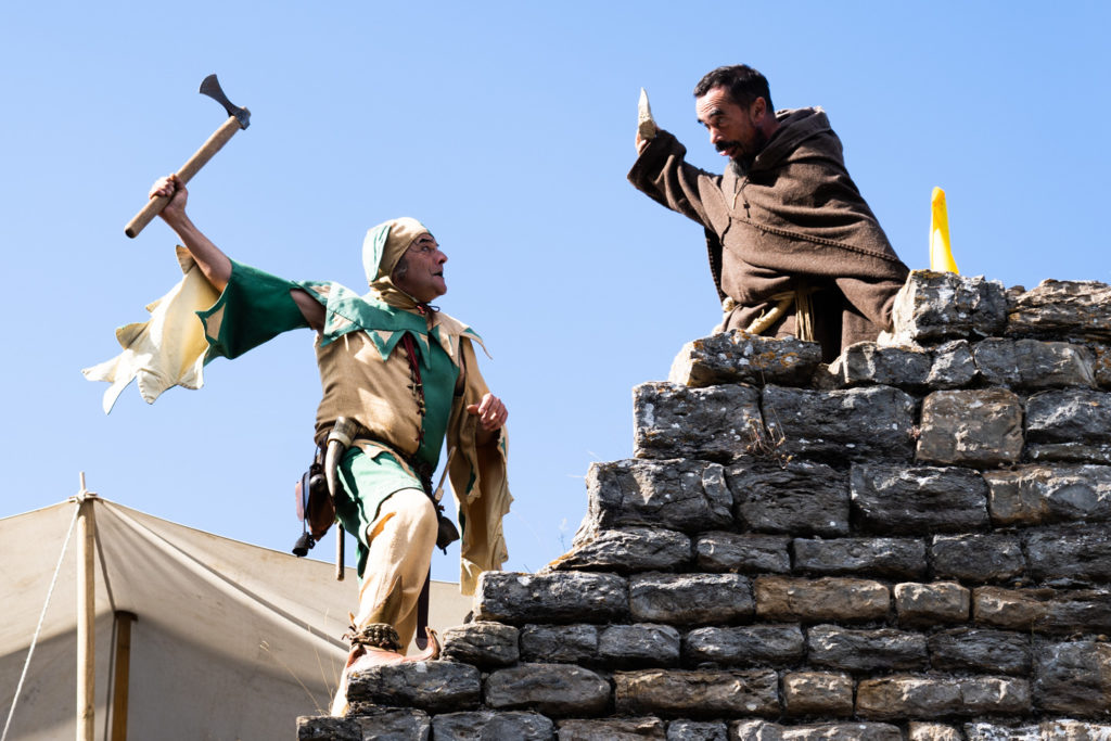 Tapaillo, fou du roi dans la compagnie médiévale "Les Faydits d'Oc", manace frère Tancrède avec une hachette lors d'une représentation de la troupe au château de Peyrelade. Rivière-sur-Tarn, août 2020.