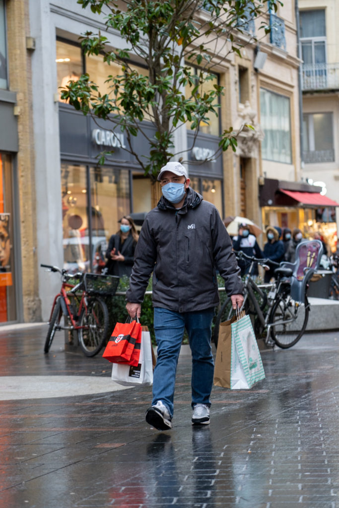 Un homme porte de nombreux sacs d'achats sur la rue Alsace Lorraine pendant les courses de Noël en centre ville. Toulouse, le 21 décembre 2020.