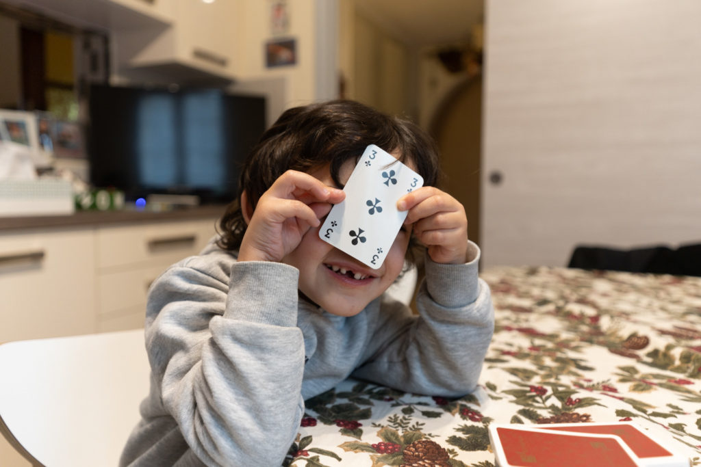 Théo cache bien son jeu pendant une partie de cartes. Alors que se profile le spectre de possibles restrictions sanitaires, les vacances de Noël ont été l’occasion pour les parents d’enfants en bas âge d’expérimenter le confinement en famille. Les jeux de société traditionnels ont connu un essor commercial considérable pendant l'année 2020. Toulouse, décembre 2020.