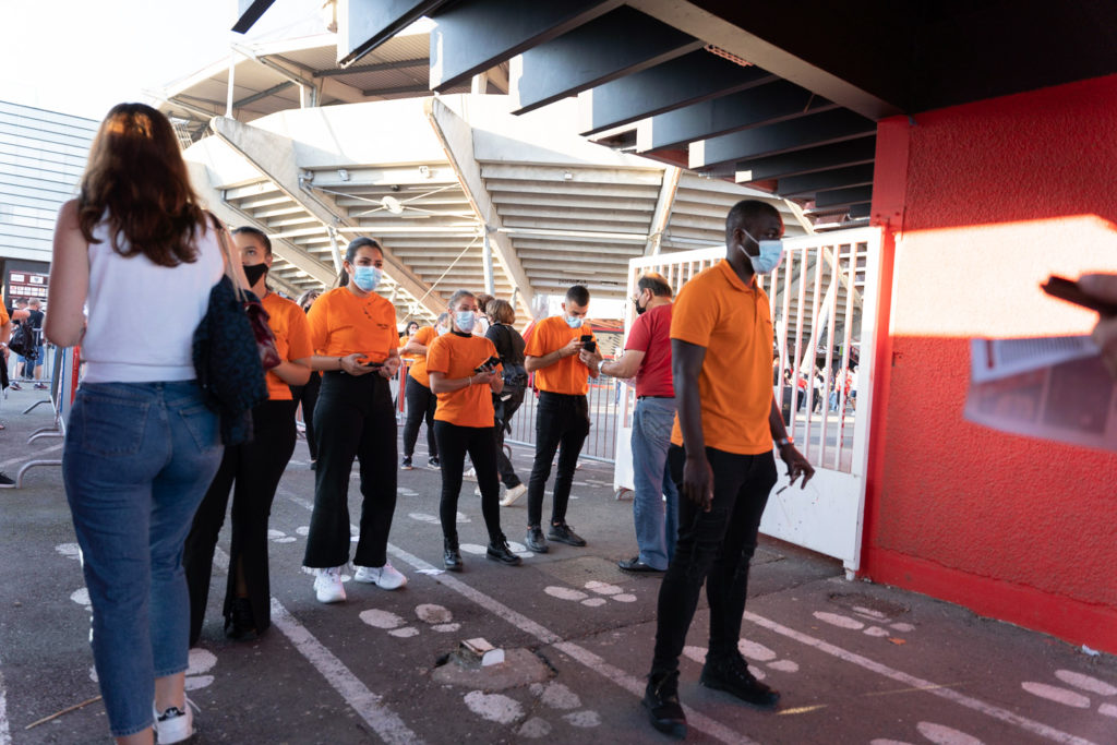 Des employés d'accueil attendent le public à l'entrée du stade. Après une année de matches à huis-clos en raison de la crise sanitaire, le public a pu de nouveau se rendre au stade Ernest Wallon à l’occasion du match de clôture de la 2e journée du Top 14. Champion de France en titre, le Stade Toulousain recevait le Rugby Club Toulonnais. Le match s'est joué à guichets fermés et près de 19000 contrôles de pass sanitaires ont été effectués à l'entrée du stade. Le Stade Toulousain l’a remporté par 41 à 10. Toulouse, stade Ernest Wallon, le 12 septembre 2021.