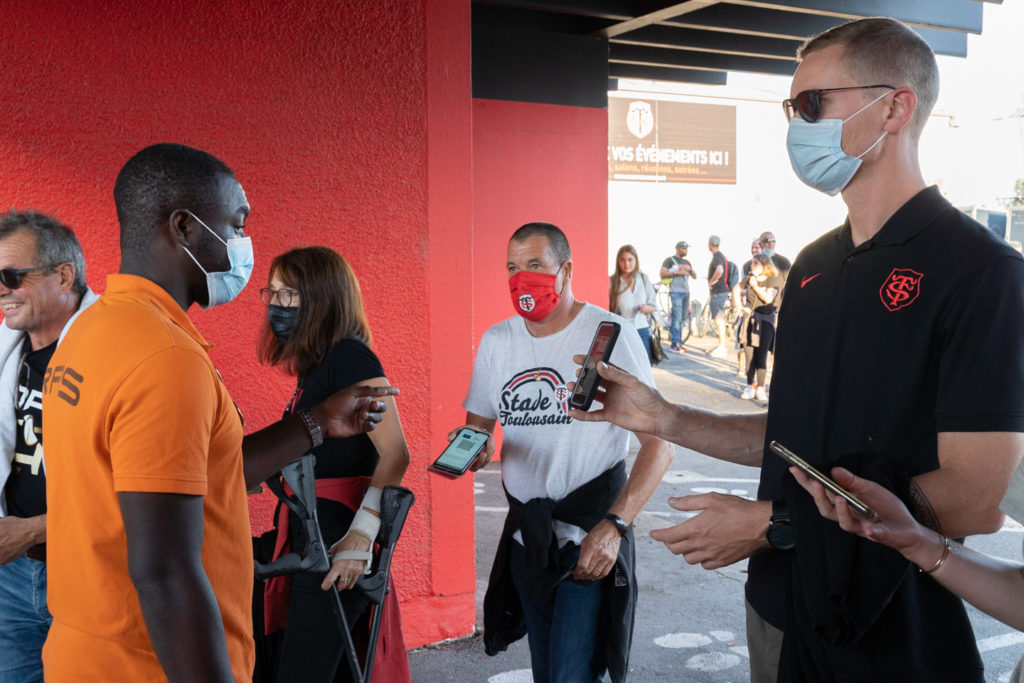 Un employé d'accueil vérifie les pass sanitaires de supporters du Stade Toulousain. Après une année de matches à huis-clos en raison de la crise sanitaire, le public a pu de nouveau se rendre au stade Ernest Wallon à l’occasion du match de clôture de la 2e journée du Top 14. Champion de France en titre, le Stade Toulousain recevait le Rugby Club Toulonnais. Le match s'est joué à guichets fermés et près de 19000 contrôles de pass sanitaires ont été effectués à l'entrée du stade. Le Stade Toulousain l’a remporté par 41 à 10. Toulouse, stade Ernest Wallon, le 12 septembre 2021.