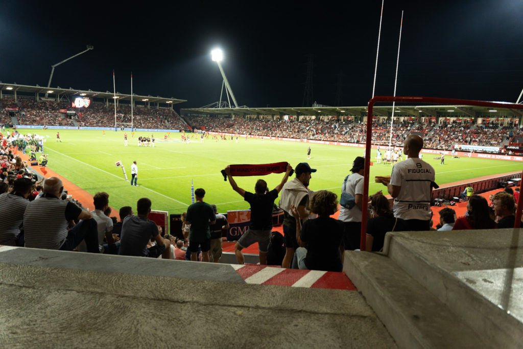 Un supporter du Stade Toulousain brandit une banderole alors que les équipes s'échauffent avant le coup d'envoi. Après une année de matches à huis-clos en raison de la crise sanitaire, le public a pu de nouveau se rendre au stade Ernest Wallon à l’occasion du match de clôture de la 2e journée du Top 14. Champion de France en titre, le Stade Toulousain recevait le Rugby Club Toulonnais. Le match s'est joué à guichets fermés et près de 19000 contrôles de pass sanitaires ont été effectués à l'entrée du stade. Le Stade Toulousain l’a remporté par 41 à 10. Toulouse, stade Ernest Wallon, le 12 septembre 2021.