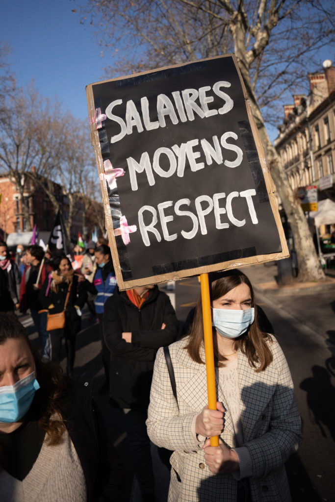 Une femme brandit une pancarte demandant un meilleur salaire, plus de moyens et plus de respect lors de la manifestation interprofessionnelle pour la hausse des salaires organisée à l’appel des organisations syndicales CGT (Confédération générale du travail), FO (Force ouvrière), FSU (Fédération syndicale unitaire) et Solidaires.  Toulouse, le 27 janvier 2022.