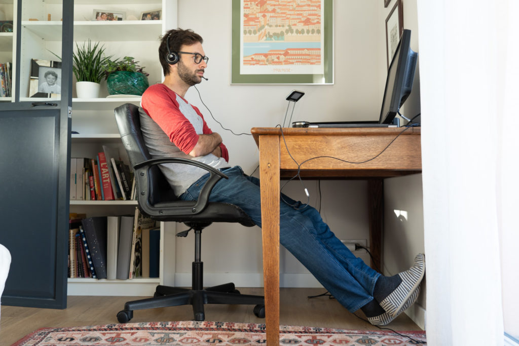 En chaussettes et pantoufles, un informaticien chez lui en télétravail perplexe devant son ordinateur. Toulouse, 26 novembre 2020.