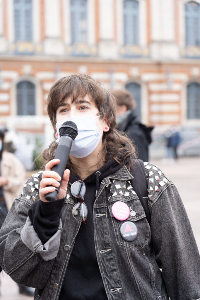 Louise Lourdon prend le micro pour dénoncer la politique sanitaire du gouvernement pendant la crise du Covid à l'occasion du rassemblement organisé par ActUp Sud-Ouest pour la journée mondiale contre le VIH/SIDA. Condamnée en première instance le 26 novembre 2019 à 300€ d'amende avec sursis "pour infjures publiques" suite à une plainte de la Manif Pour Tous concernant une contre-manifestation ayant eu lieu en 2017, elle a fait appel. Le tribunal de grande instance de Toulouse rendra son jugement le 8 décembre. Toulouse, le 1er décembre 2020.