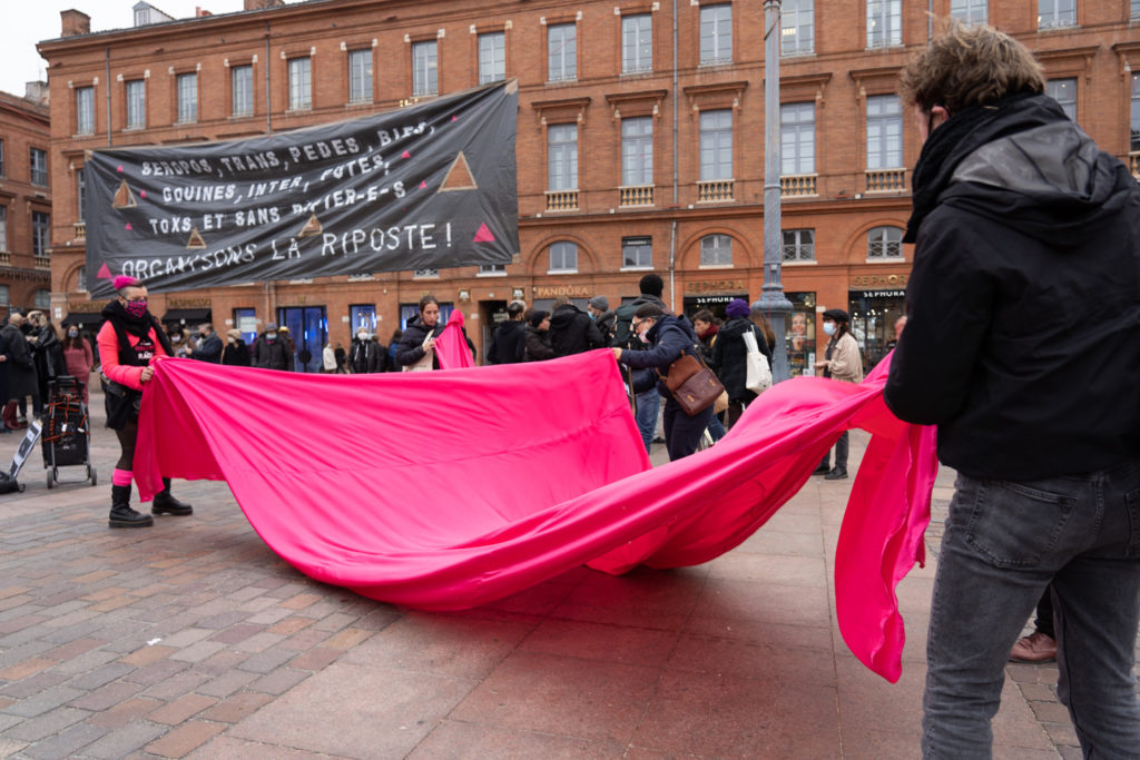 Des militants d'Act Up déploient un grand triangle rose en tisse sur les pavés de la place du Capitole, à Toulouse, à l'occasion du rassemblement organisé par ActUp Sud-Ouest pour la journée mondiale contre le VIH/SIDA.  Ils dénoncent notamment la politique sanitaire du gouvernement pendant la crise du Covid. Toulouse, le 1er décembre 2020.