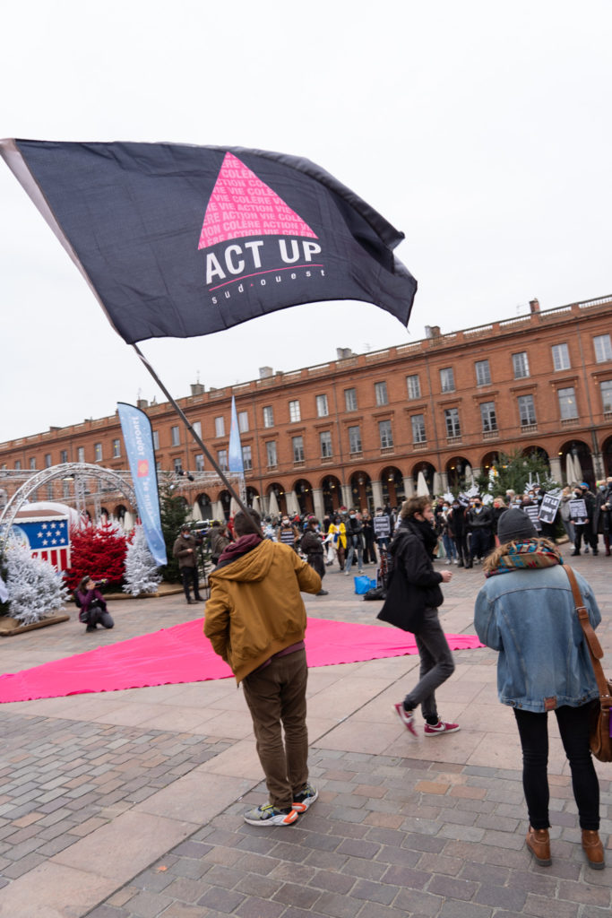 Un militant brandit le drapeau Act Up sur la place du Capitole à l'occasion du rassemblement organisé par ActUp Sud-Ouest pour la journée mondiale contre le VIH/SIDA. Toulouse, le 1er décembre 2020.