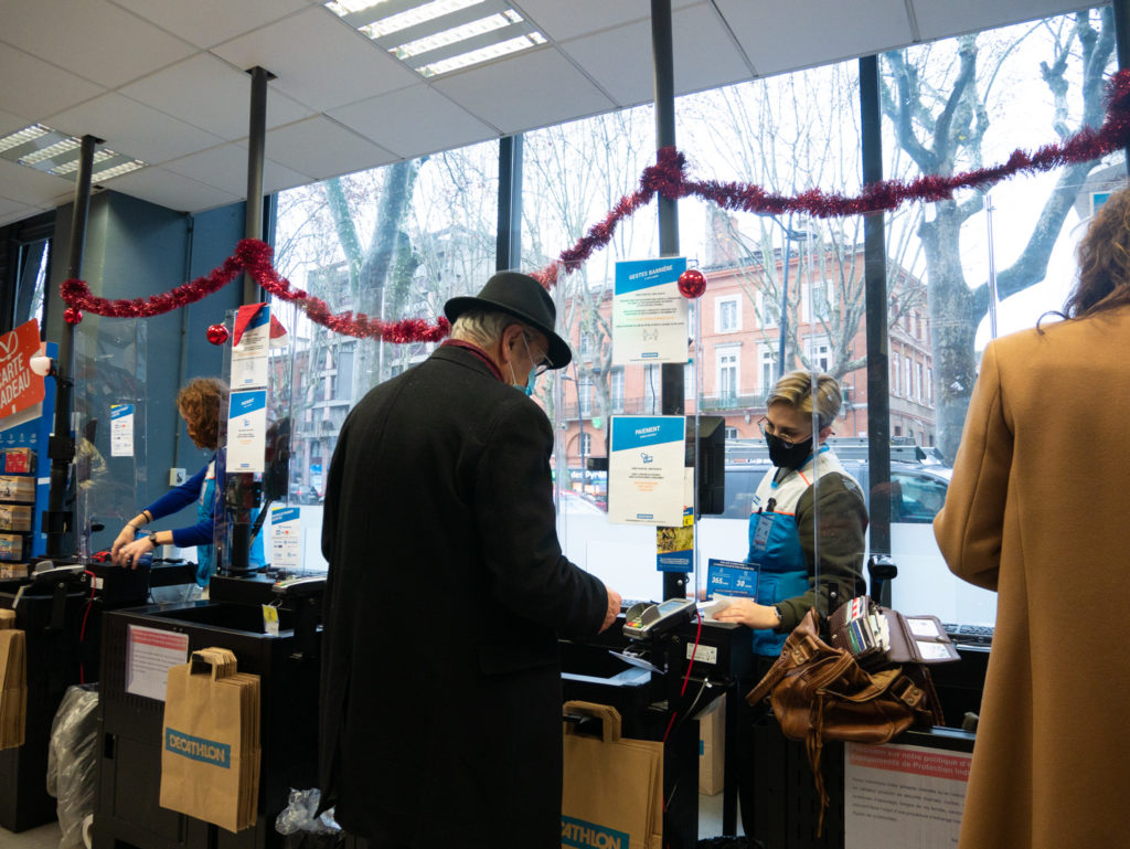 Un homme âgé passe à la caisse d'une grande enseigne pendant les courses de Noël. Toulouse, le 21 décembre 2020.