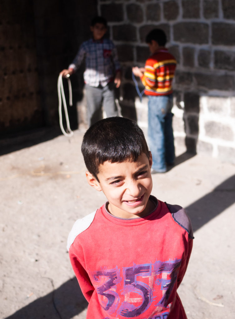 Des enfants jouent dans la rue. Un d'entre eux pose pour la photographie. Diyarbakir (Turquie), novembre 2010.