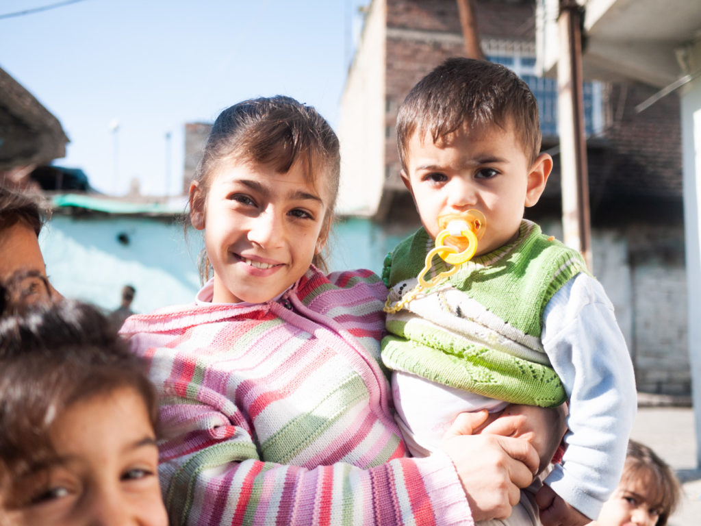 Une petite fille tient son petit frère dans ses bras. Diyarbakir (Turquie), novembre 2010.