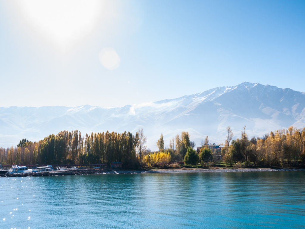 Les rives boisées du lac Van, un petit port touristique et les hautes montagnes au sud du lac vus depuis le bâteau menant à l'île d'Akdamar.  Van (Turquie), novembre 2010.