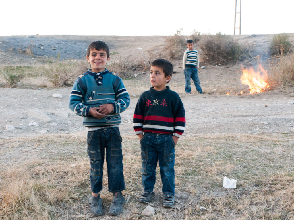 De jeunes garçons ont allumé un petit feu de broussailles dans un terrain vague à proximité de la forteresse de Van. Van (Turquie), novembre 2010.