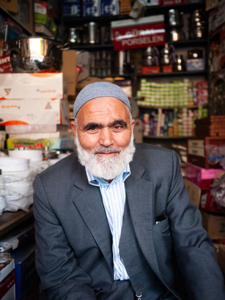 Un vieil homme barbu et coiffé d'un chapeau de prière devant sa quincaillerie. Urfa (Turquie), novembre 2010.