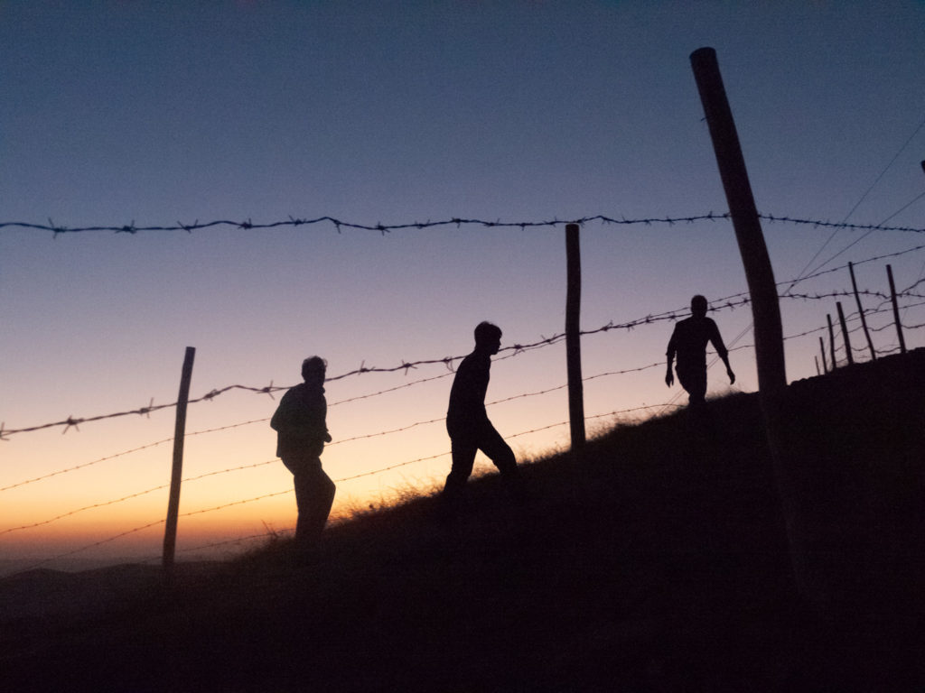 Trois touristes gravissent la colline de Göbeklitepe alors que le soleil se couche. Göbeklitepe (Turquie), novembre 2010.